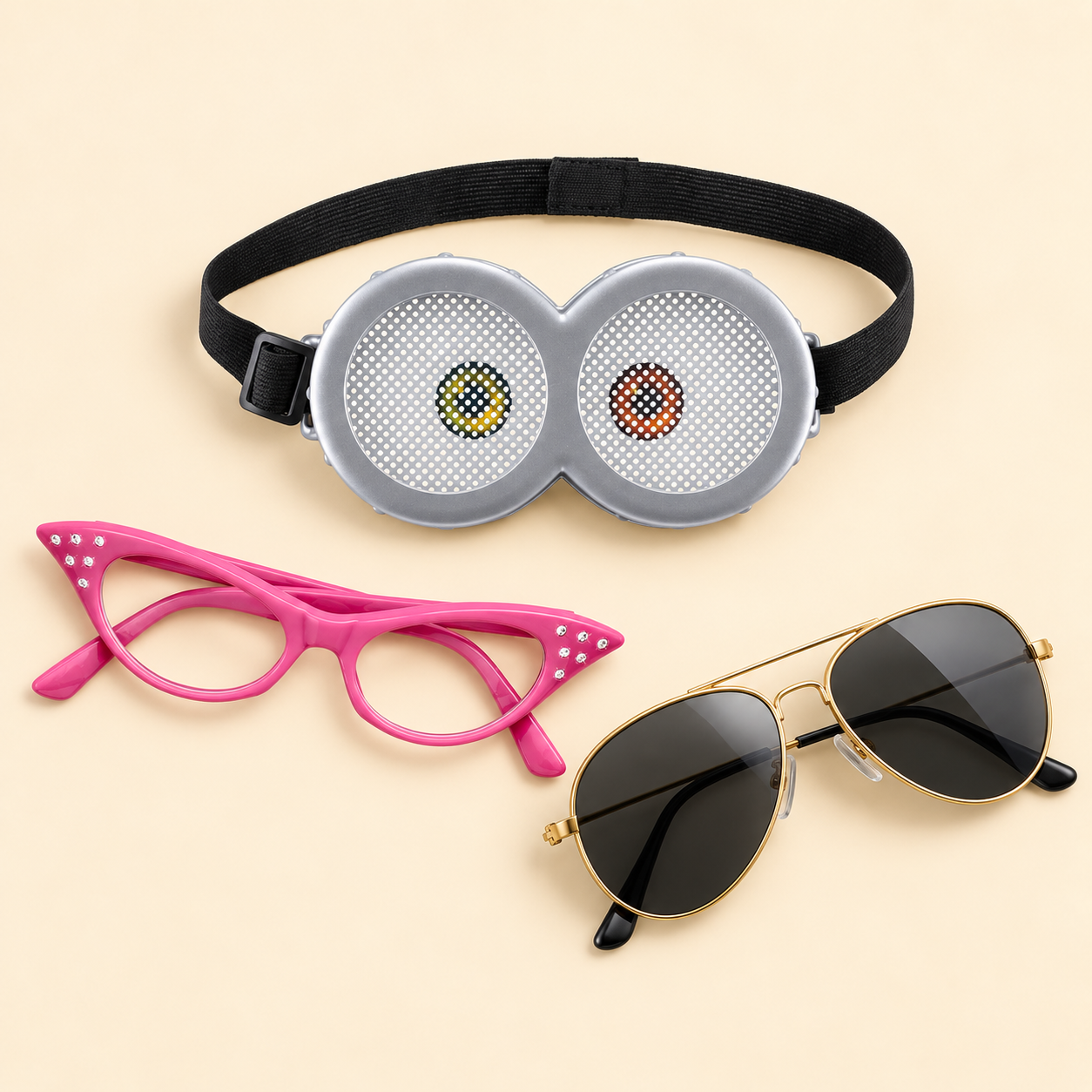 Silver Minions Bob goggles, pink rhinestone cat-eye glasses, and gold aviator sunglasses on a cream background.