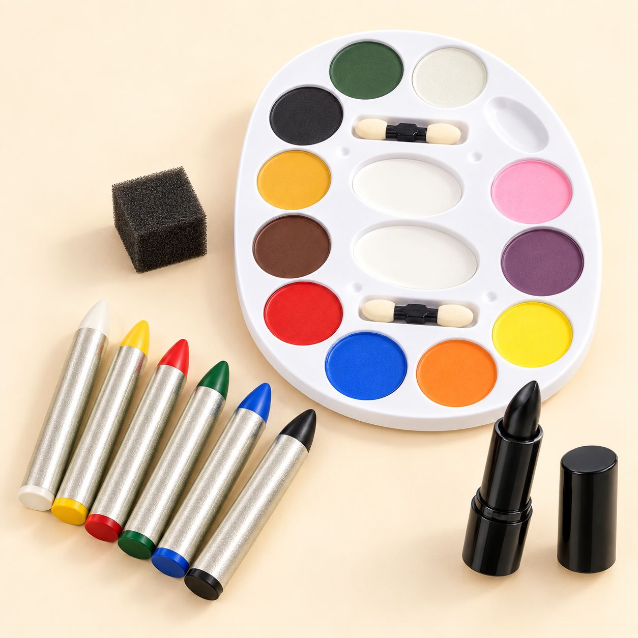 Colorful costume makeup palette, six bright makeup sticks and black lipstick on a cream background.